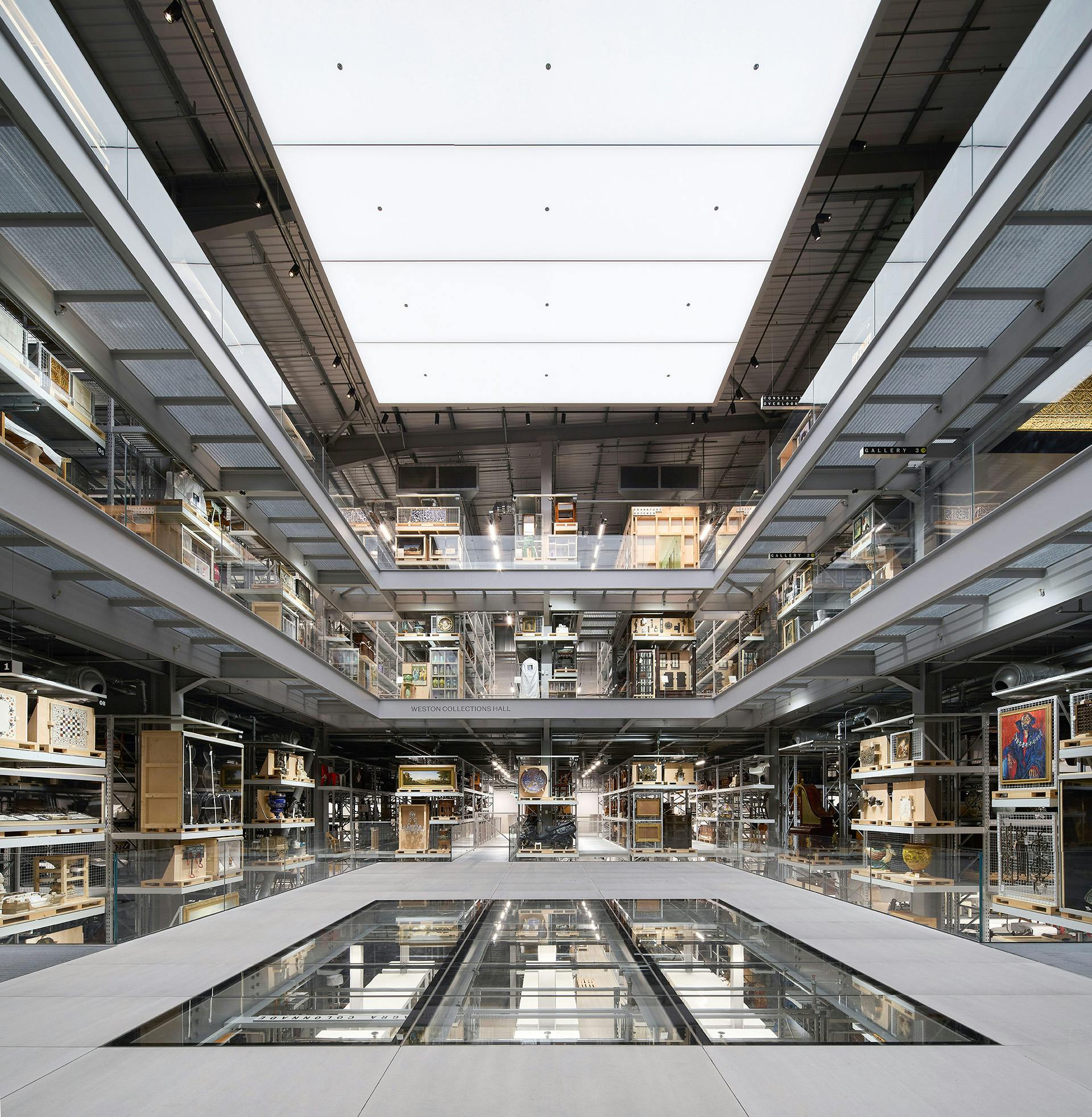 Inside the V&A East Storehouse featuring a main floor with a partial glass section and multiple levels surrounding it on all sides