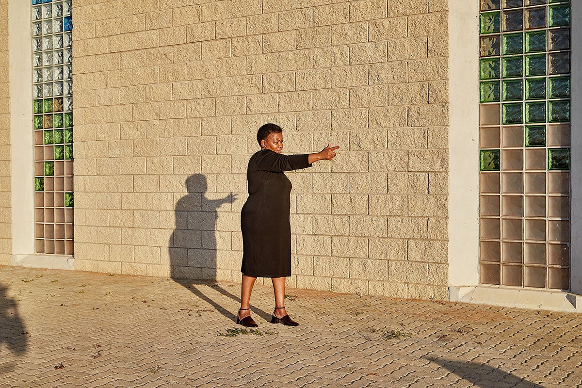Photo by Thero Makepe of a woman in a dress holding her arm out as though pointing a gun