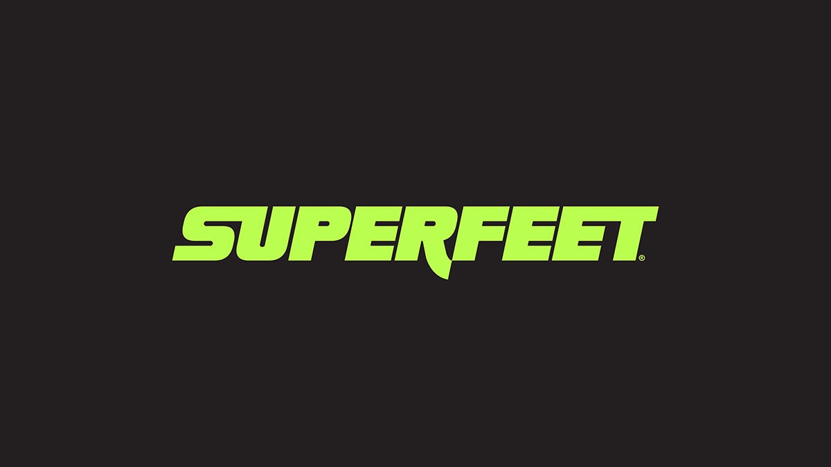 Bright green slanted Superfeet wordmark on a black background