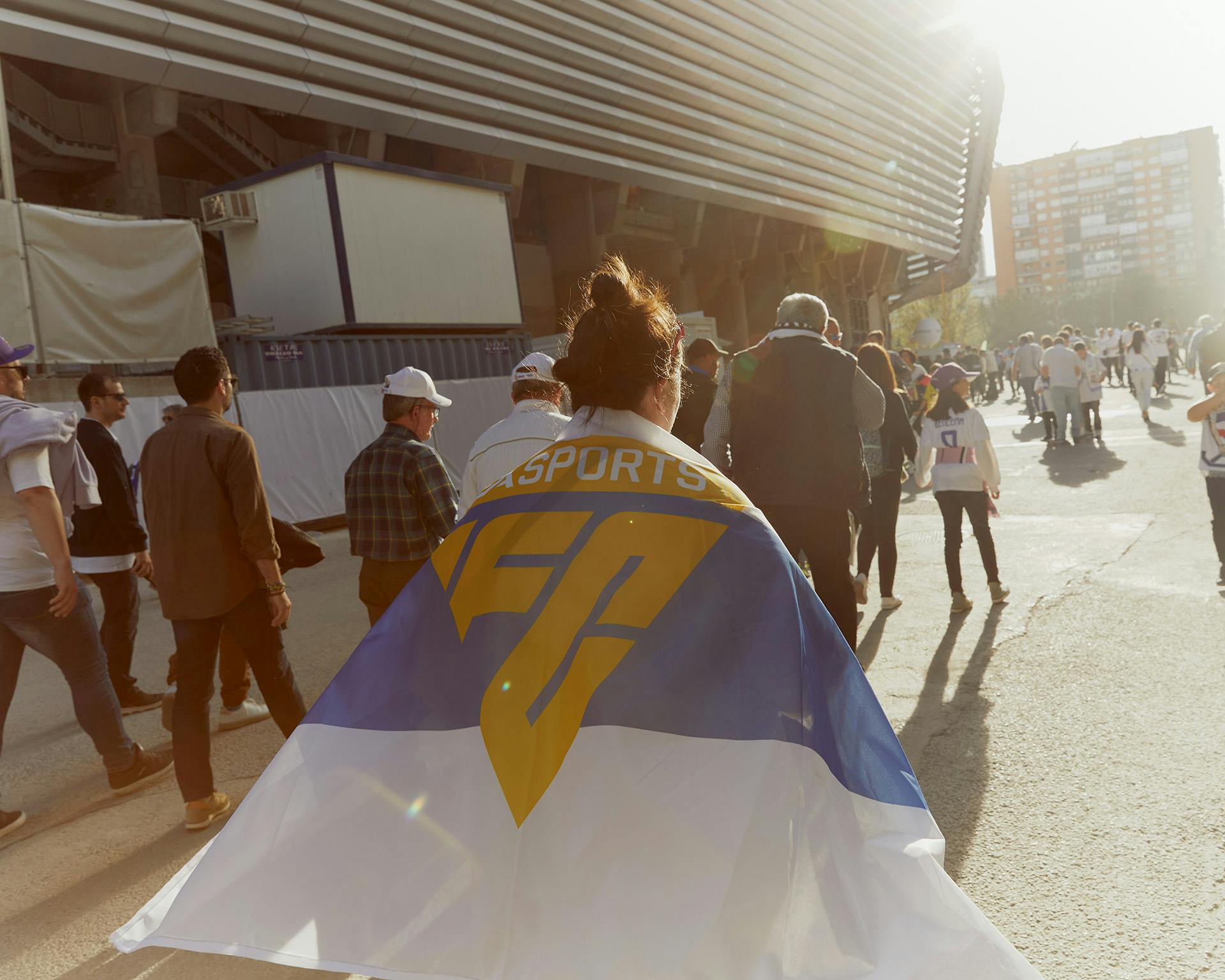 Image showing the new triangular EA Sports FC logo in yellow printed on a flag being worn by a football supporter