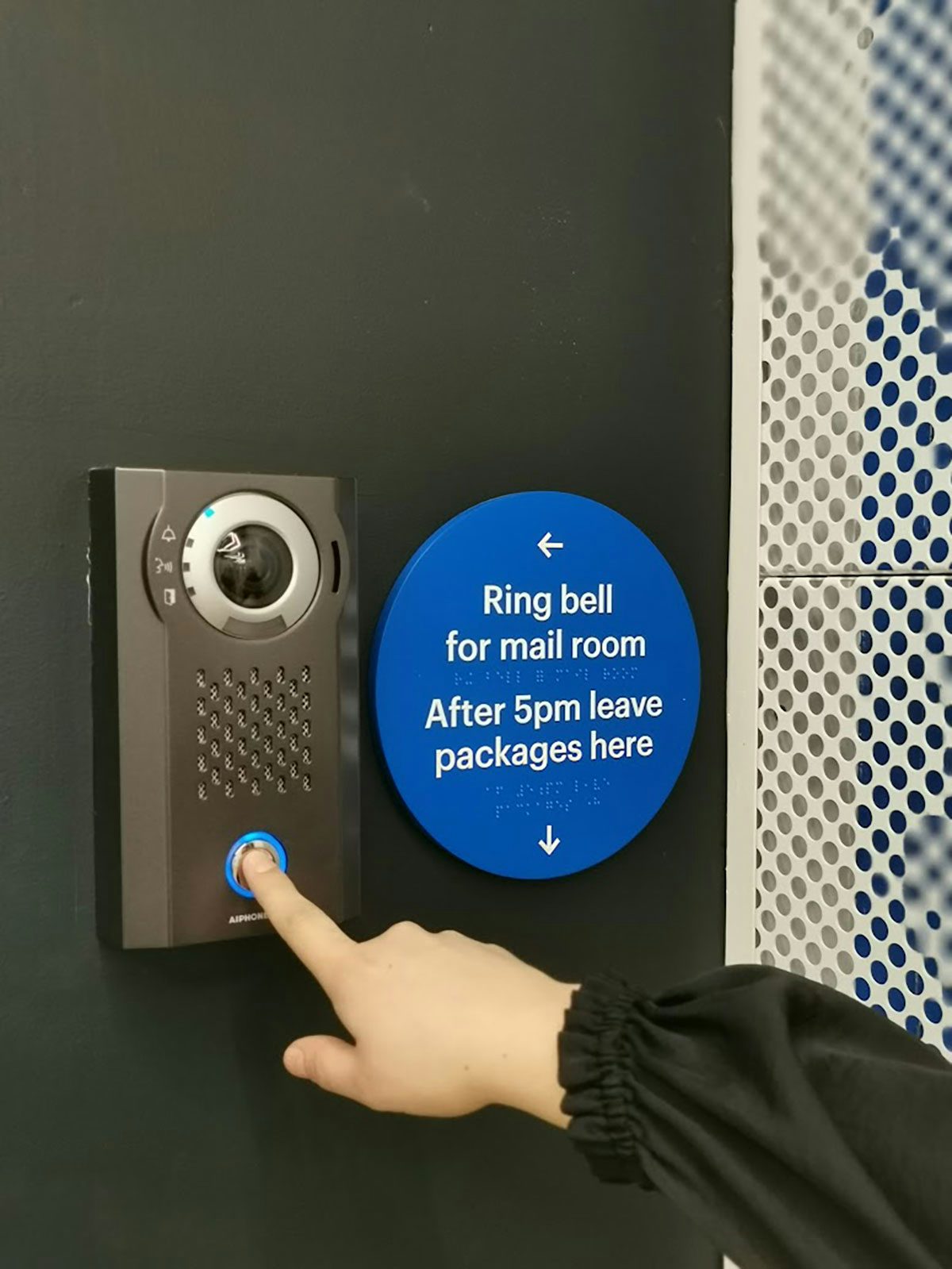 A building buzzer sign with text and braille explaining which buzzer to press depending on the time of day