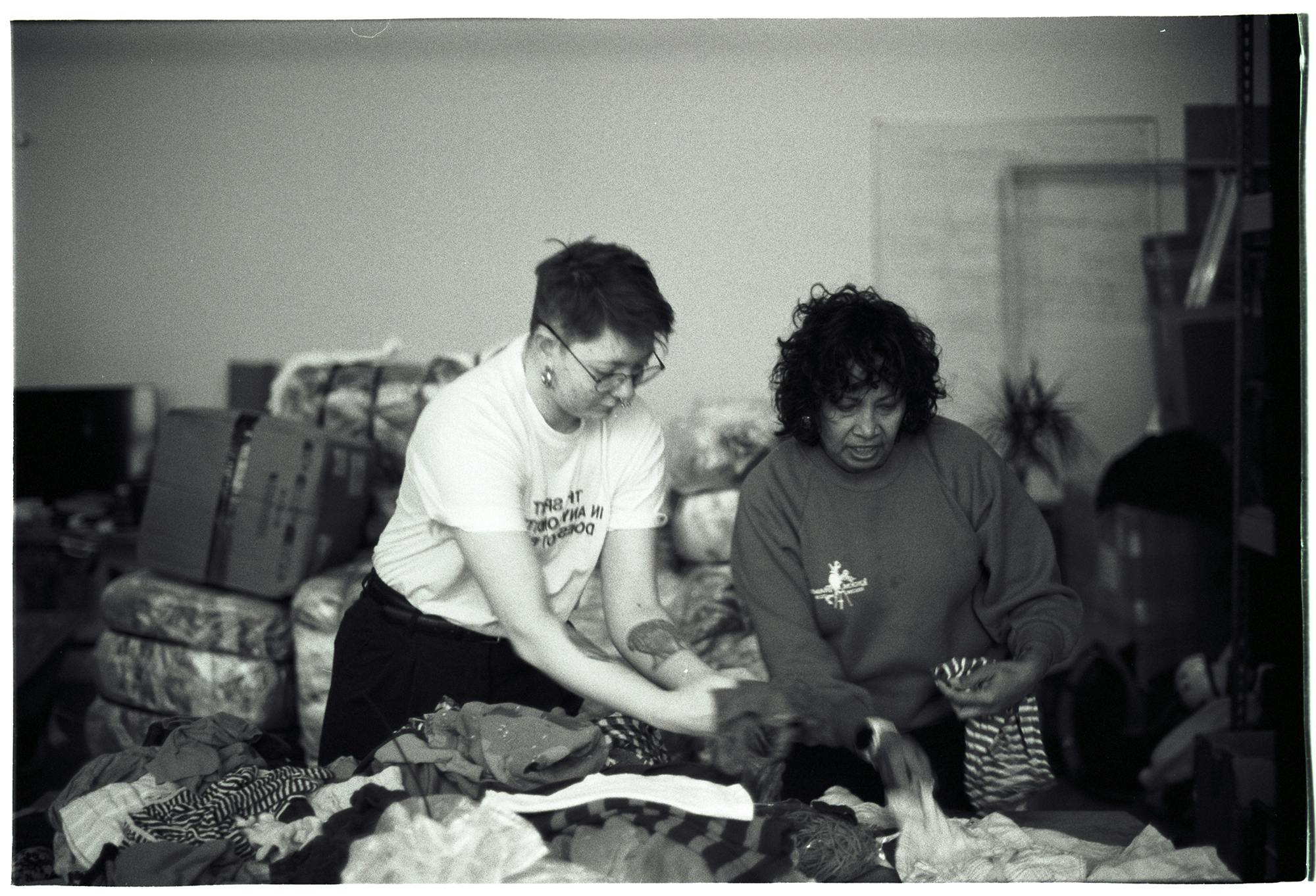 Two women sort children's clothing