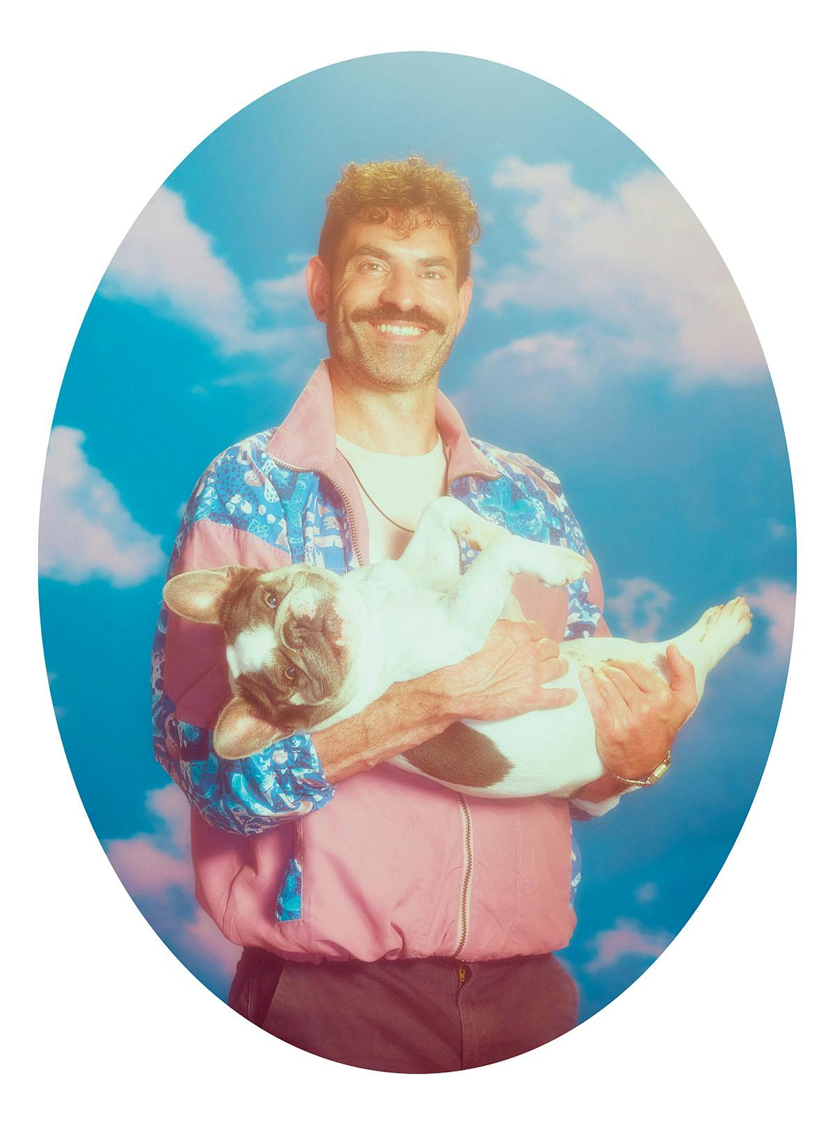 A person holding a small dog in their arms shot by Jakub Gessler in the style of a school photo against a fake cloud backdrop