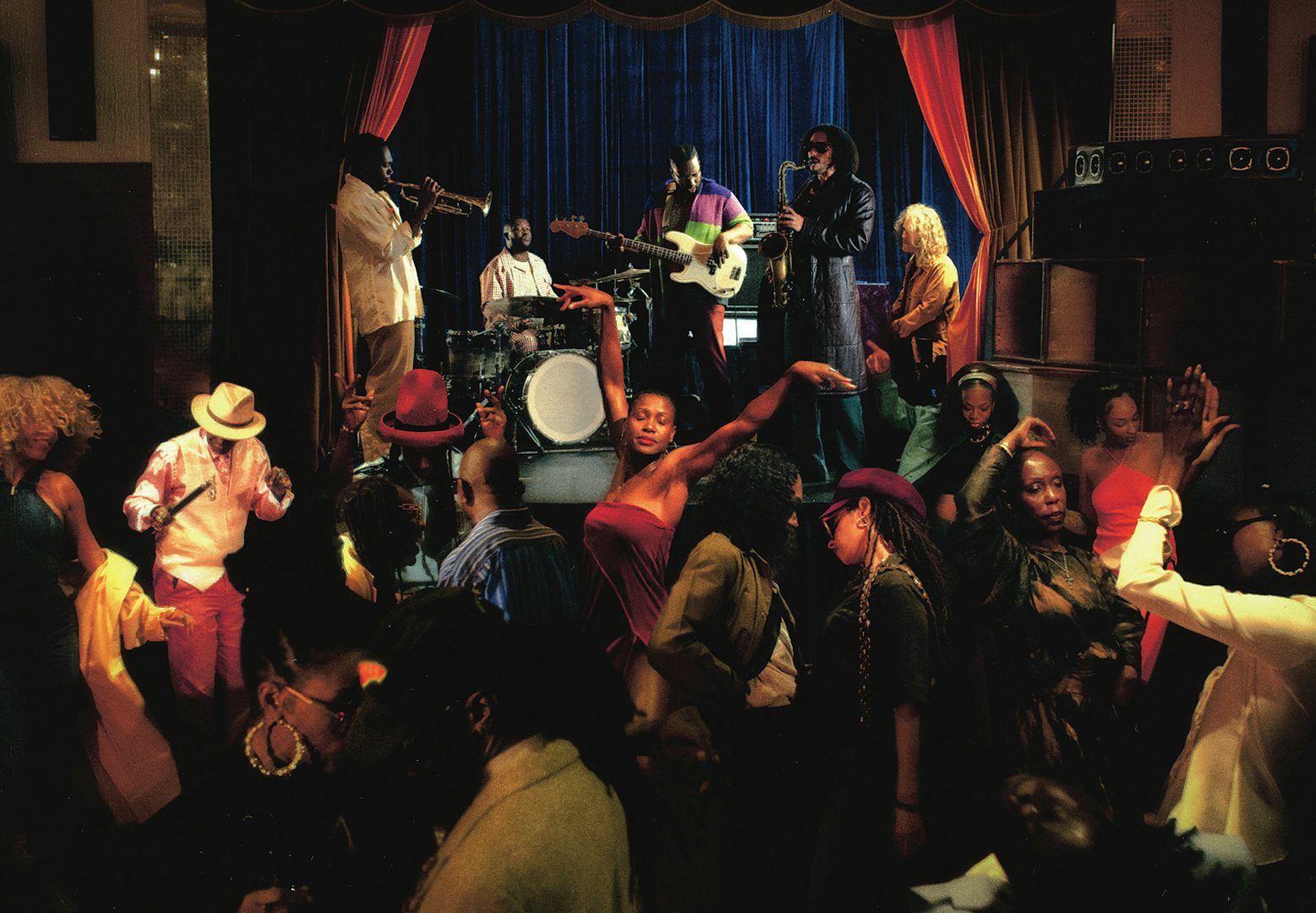 Album art for Dance No Ones Watching by Ezra Collective featuring a crowd dancing in a darkened room in front of the band on stage