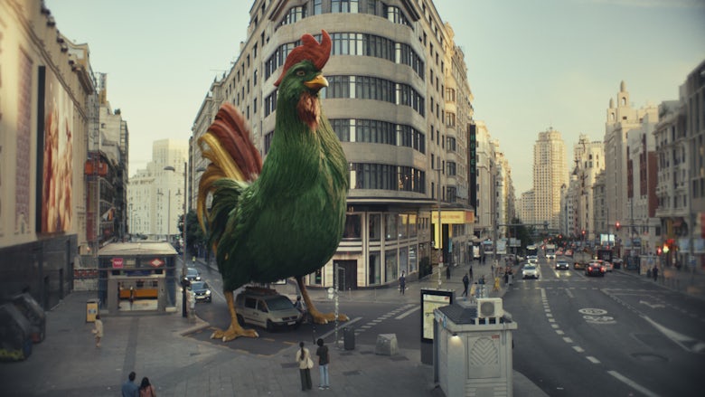 Still from a Kellogg's advert showing an enlarged green 3D animated cockerel based on the brand's mascot towering over a city street
