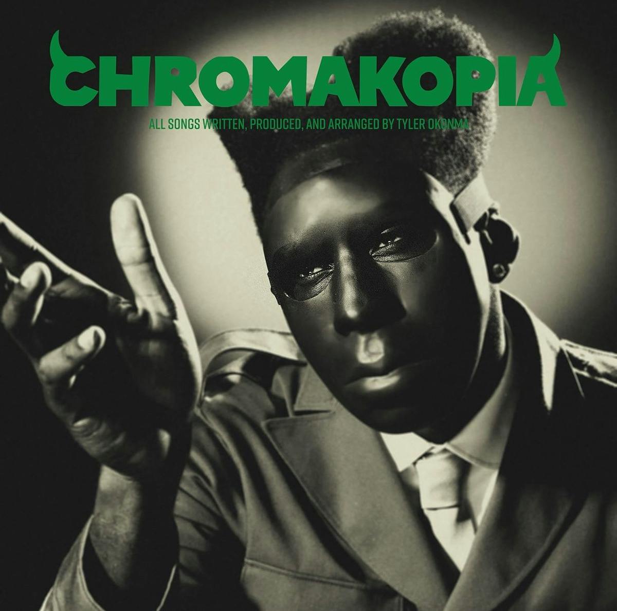 Album art for Chromakopia by Tyler The Creator featuring a sepia image of the musician in a mask and a suit holding out his hand, and the album name laid out in green font with fangs on the first and last letters