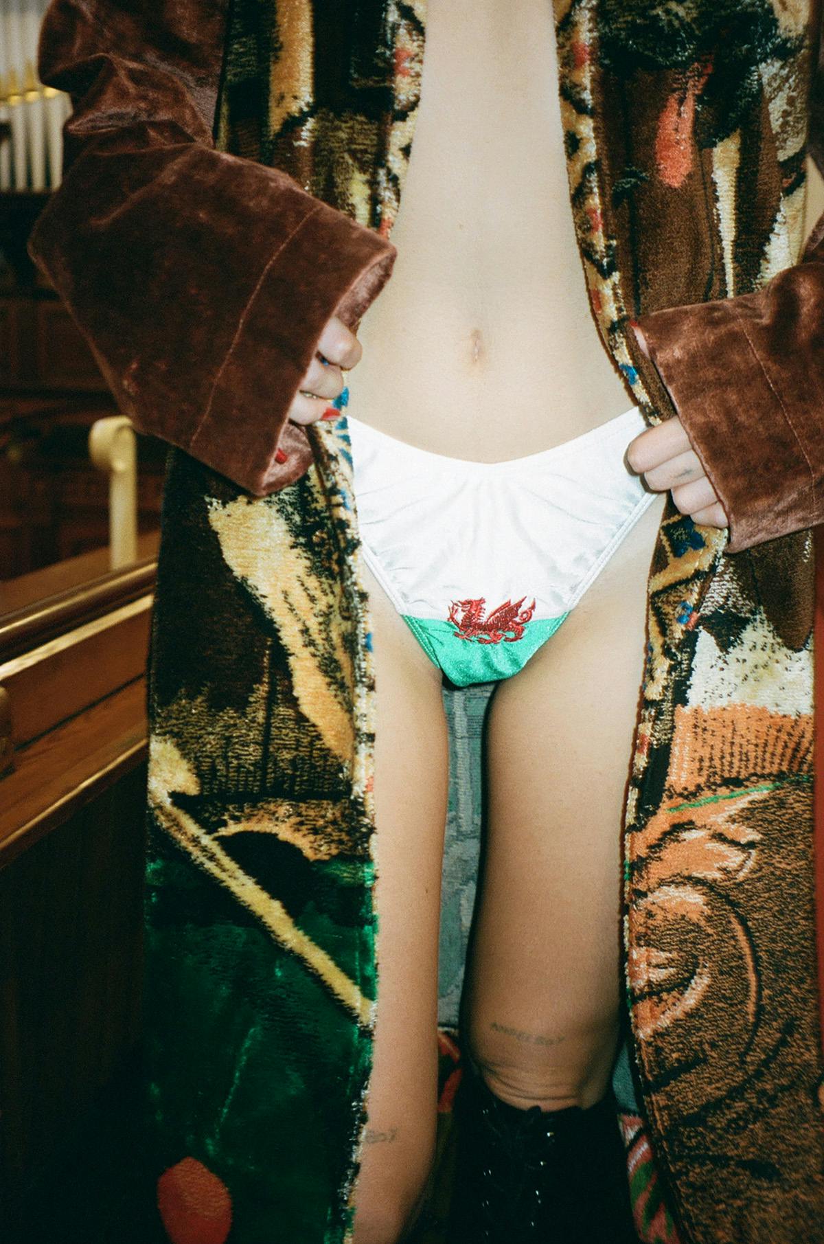 Photo by Llyr Evans showing a close-up of a person wearing Welsh flag underwear and a patterned coat