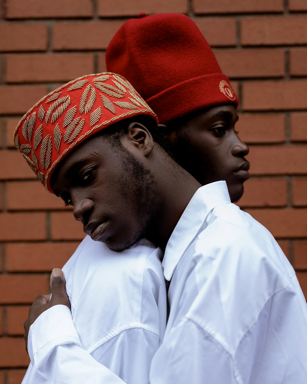 Photo by Taiye Omokore showing two young people embracing while wearing white shirts and red headdress