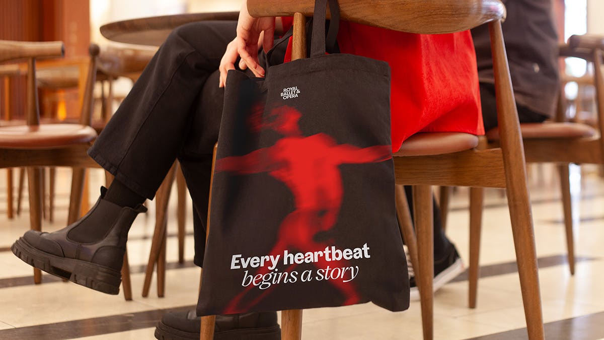 Booklet headlined 'Every heartbeat begins a story' laid over a red abstract image of a body