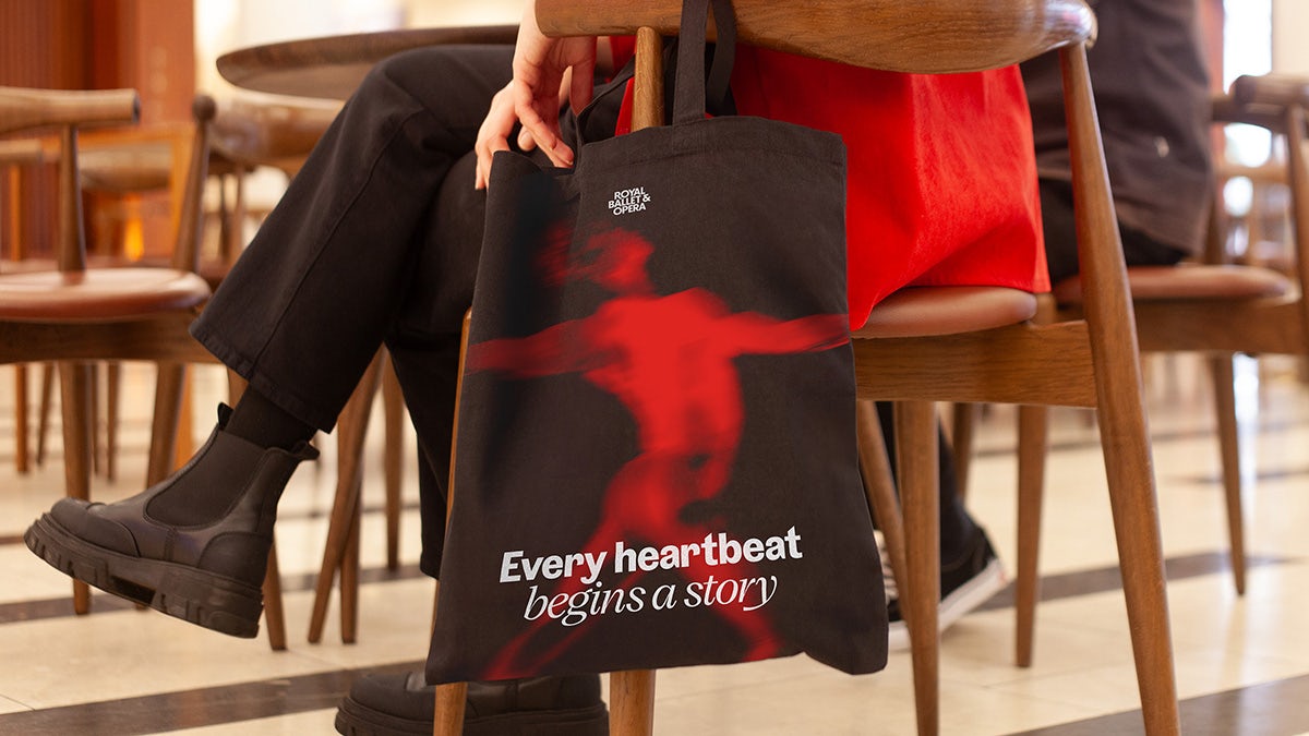 Booklet headlined 'Every heartbeat begins a story' laid over a red abstract image of a body