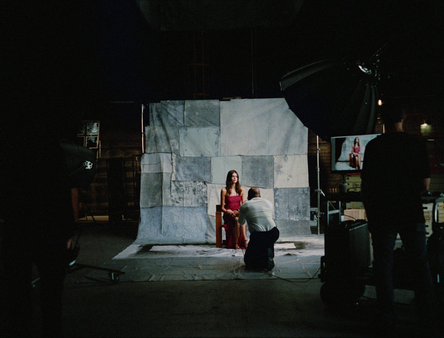 Still from Mango's campaign film by Rubberband featuring Kaia Gerber on a photoshoot with a patchwork backdrop behind her
