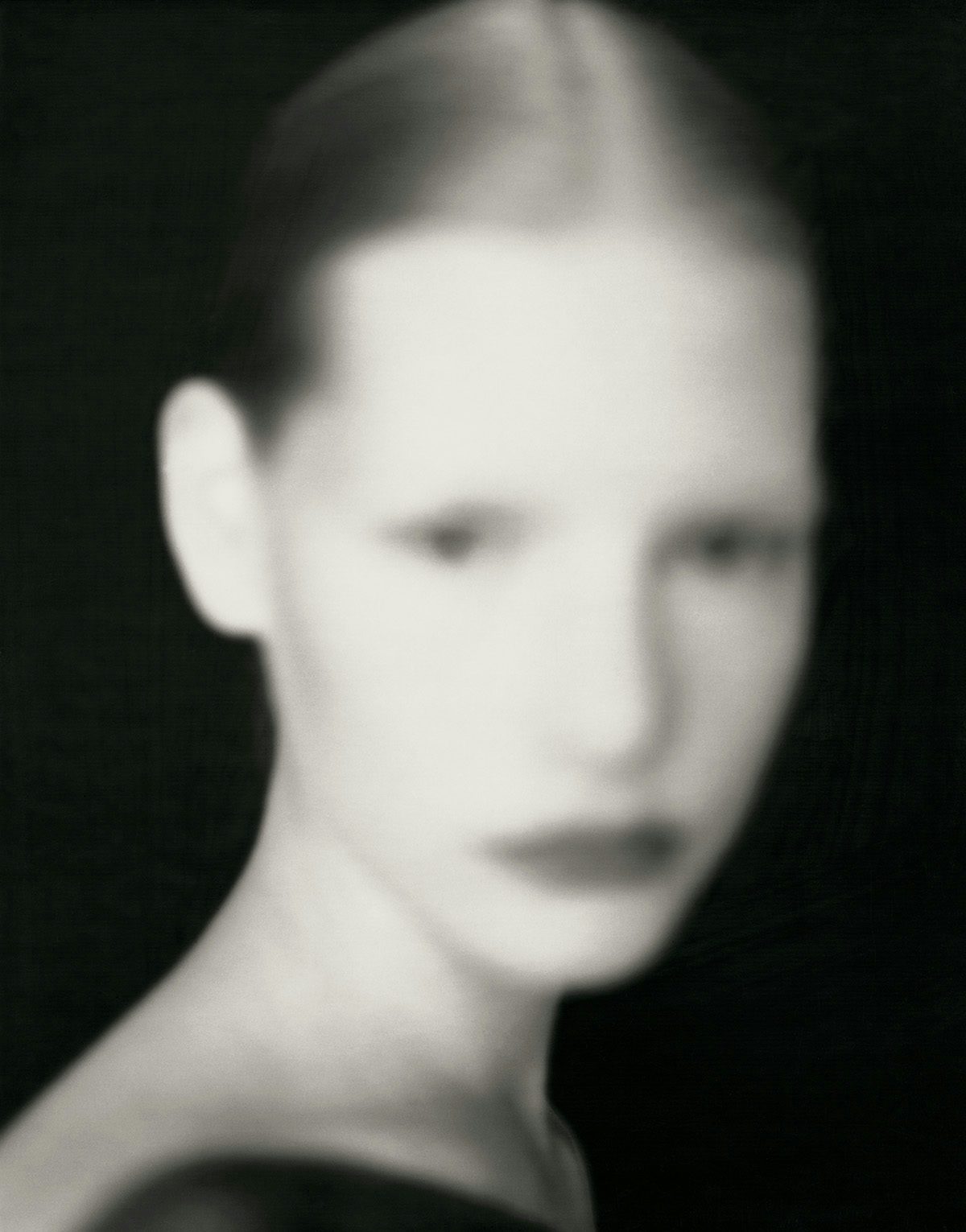 Blurred black and white portrait photo by Paolo Roversi of a model with their hair tied back