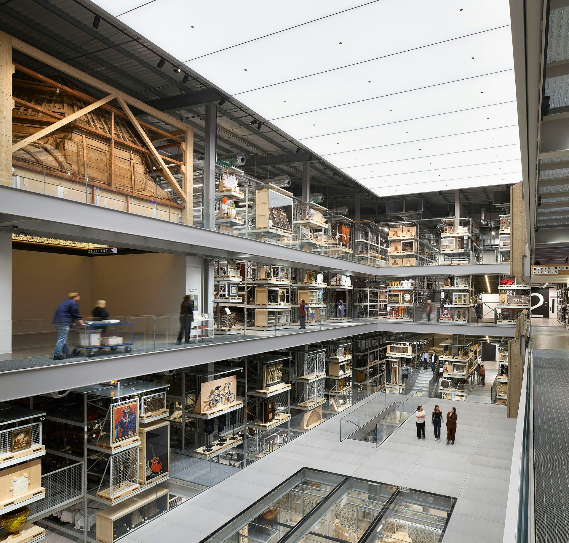 Inside the V&A East Storehouse featuring a main floor with a partial glass section and multiple levels surrounding it on all sides