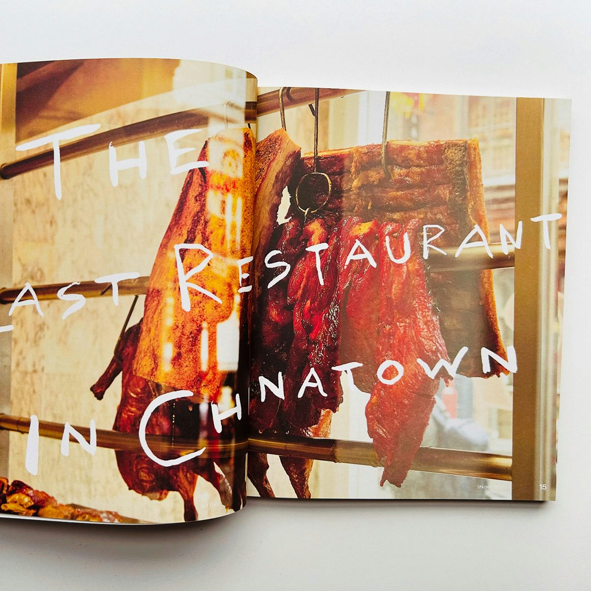 Spread from issue one of Vittles magazine headlined 'the last restaurant in Chinatown' in handwritten lettering laid over a photo of meat