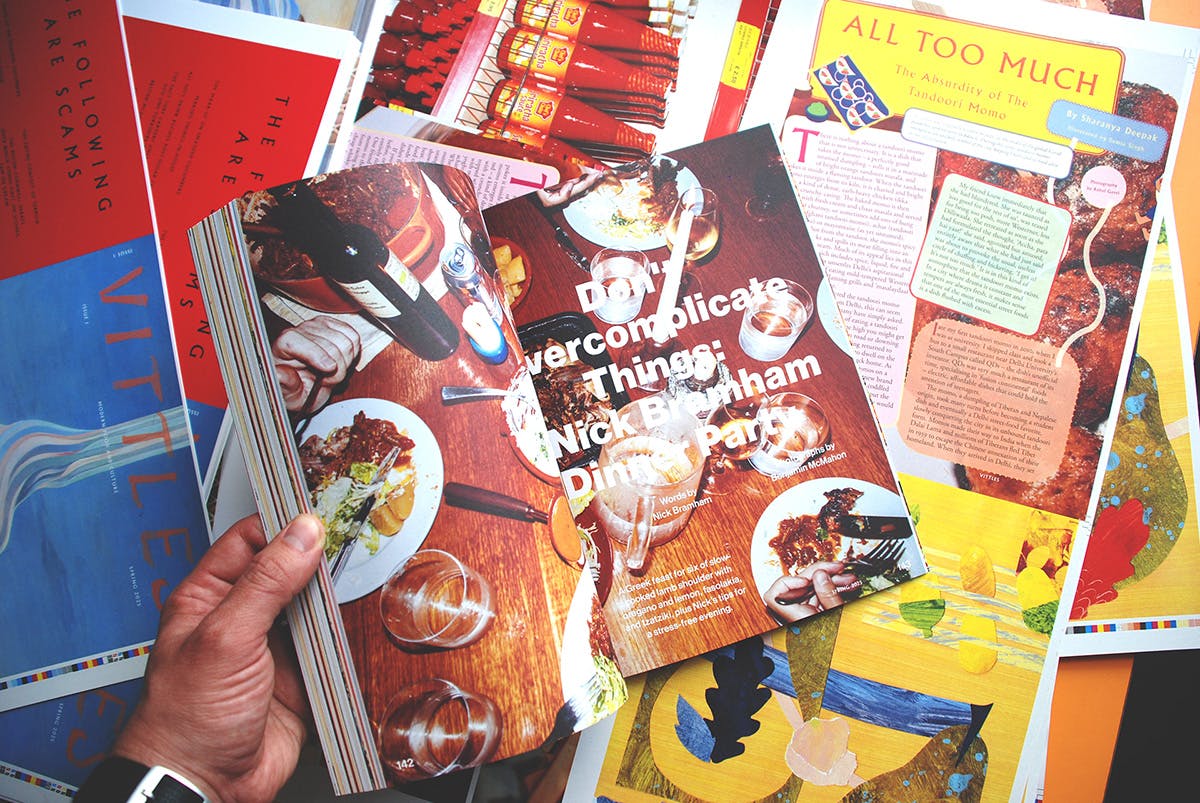 Spread headlined 'Don't Overcomplicate Things: Nick Bramham Dinner Party' with an image of a table covered in plates of food in the background