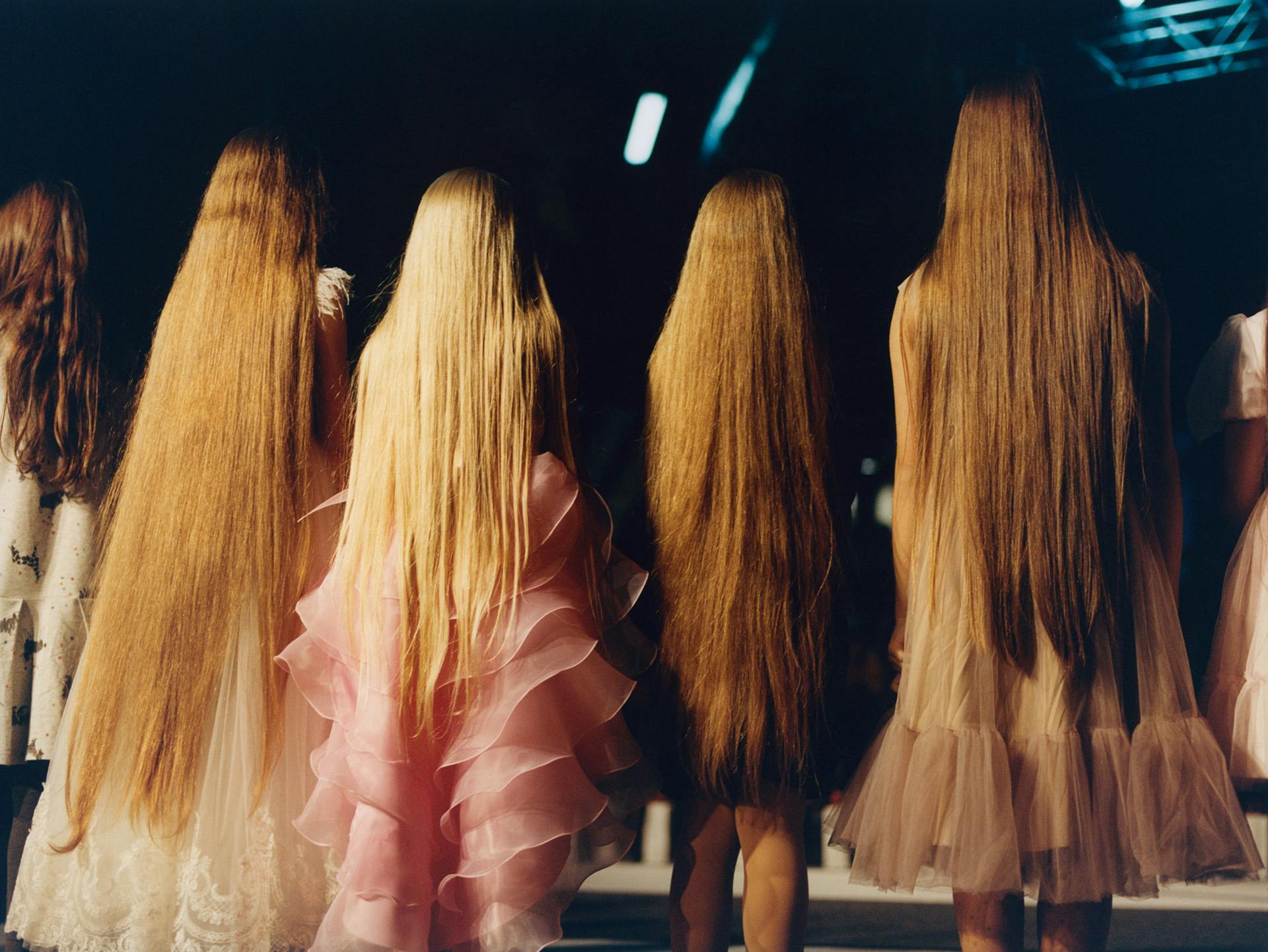 Photo by Francesca Allen of four young people with frilly dresses and very long hair