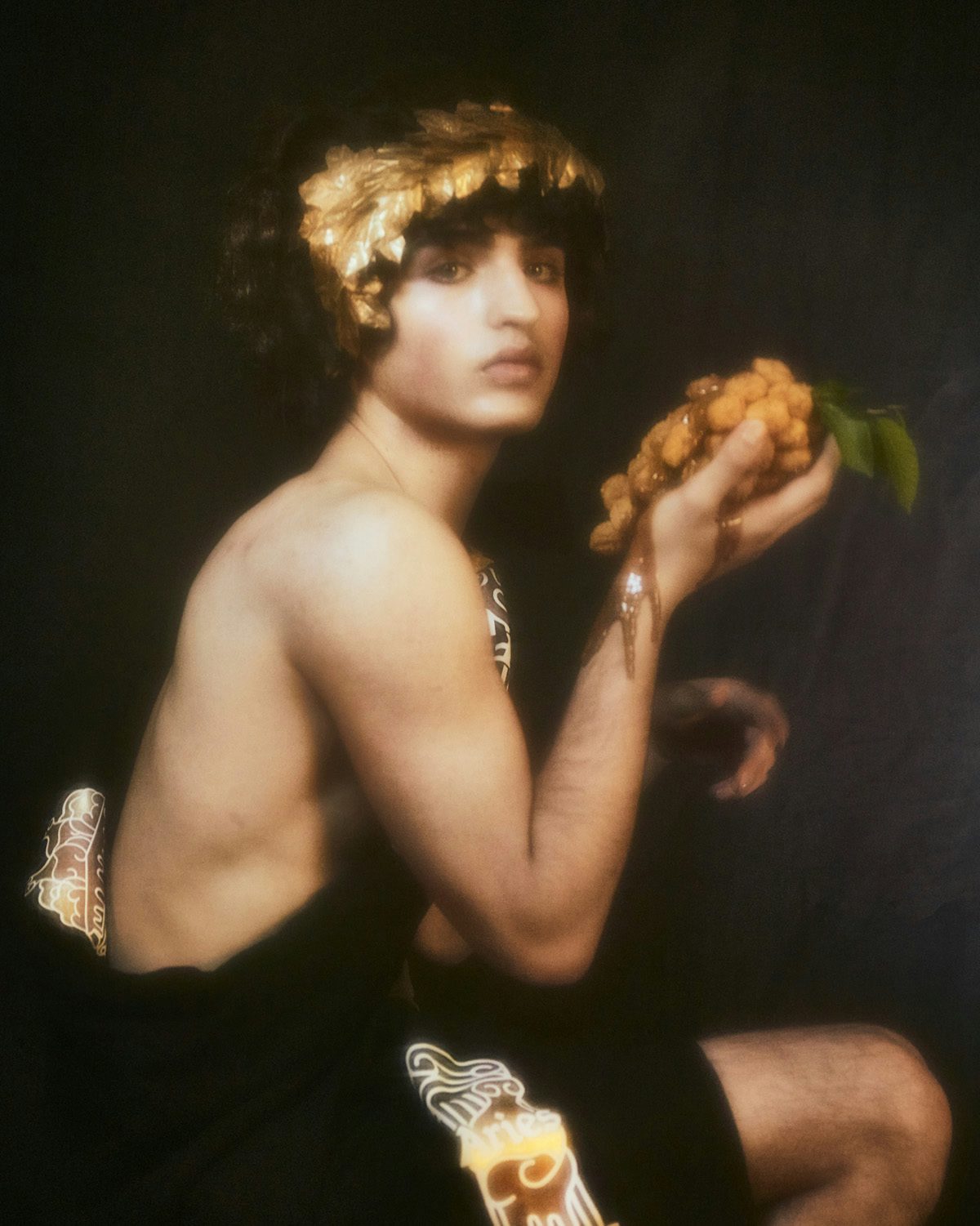 Soft focus photo of a person wearing a laurel and with a bare torso holding up a piece of KFC chicken