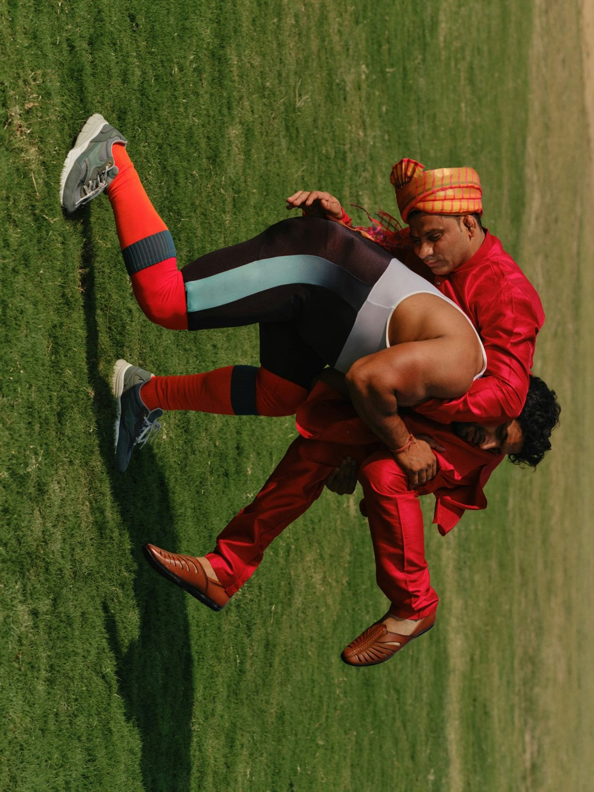 Photo by Vivek Vadoliya of two men interlocking bodies as though in combat or dance