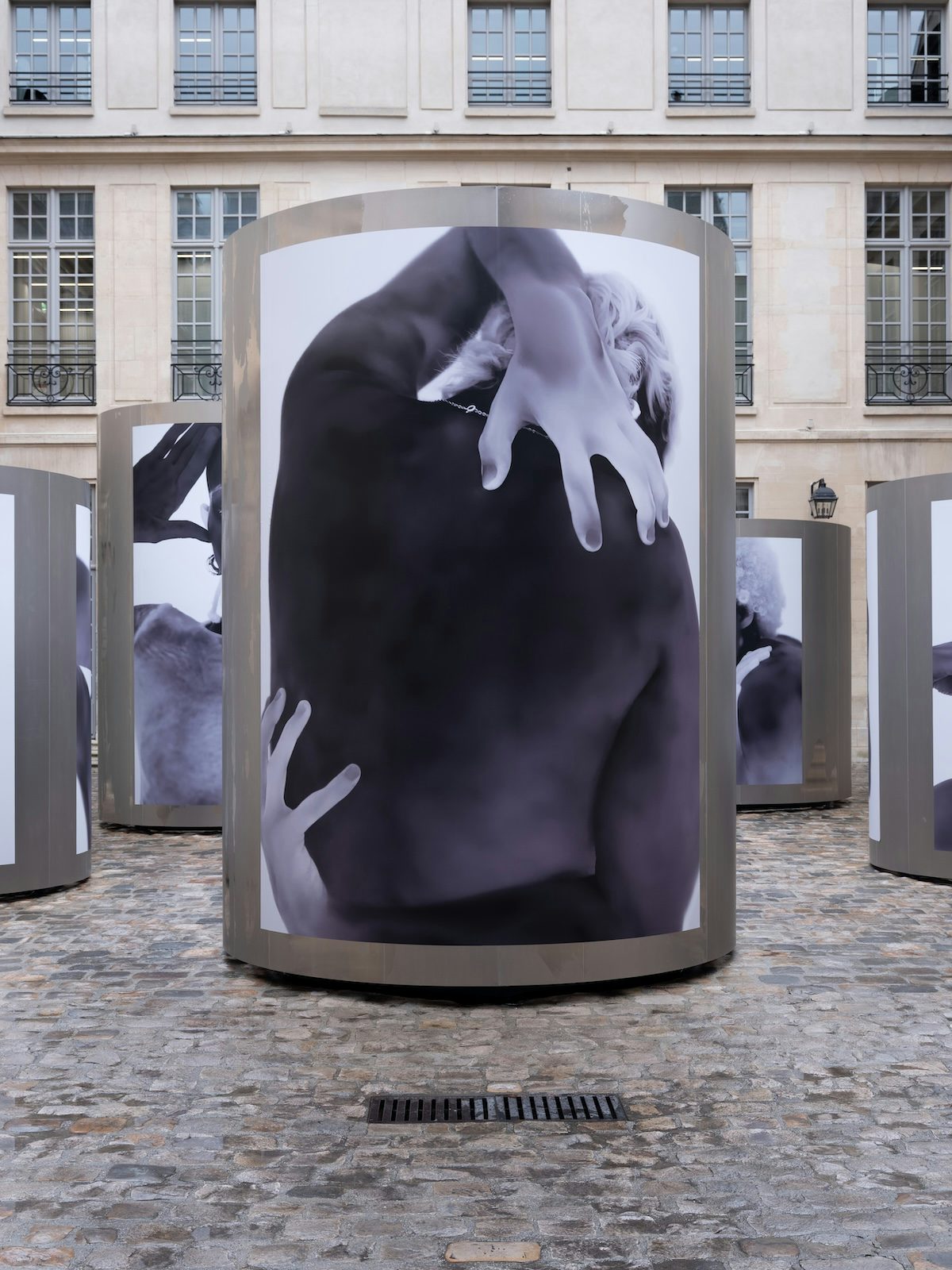 Thermal image of a person contorting their arms and bare back by Yulia Mahr displayed on a pillar outside Dover Street Market Paris