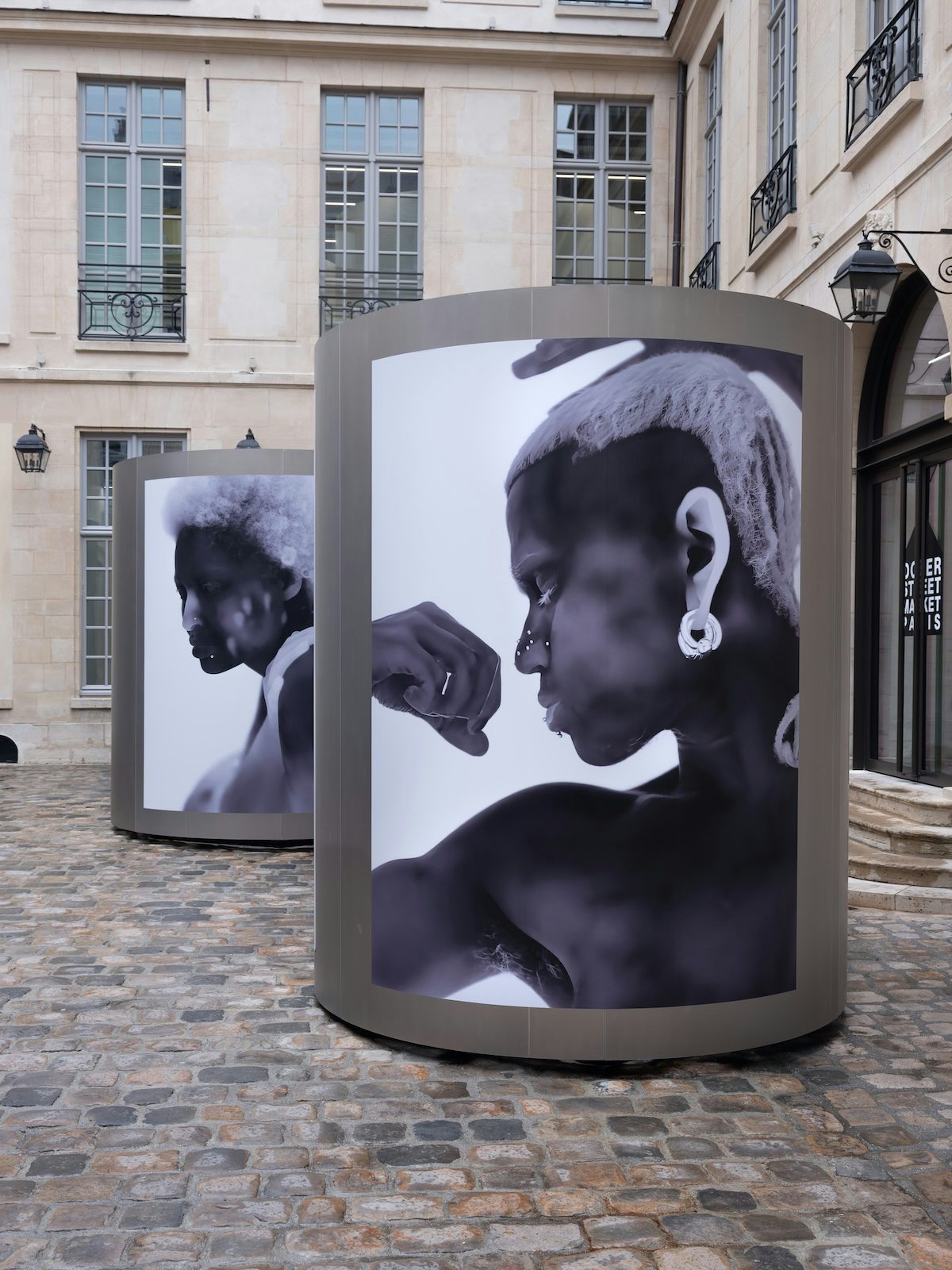 Thermal image of a person flexing their bicep by Yulia Mahr displayed on a pillar outside Dover Street Market Paris