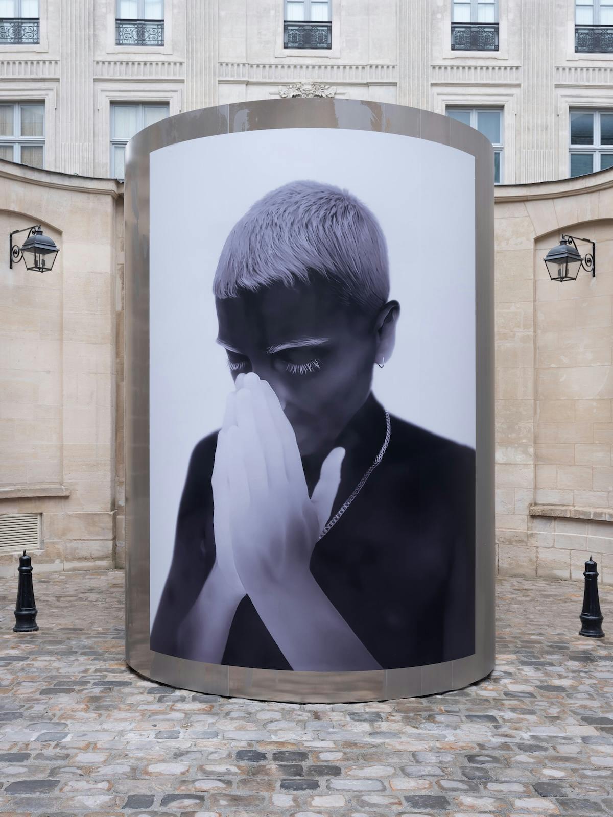Thermal image of a person cupping their own face by Yulia Mahr displayed on a pillar outside Dover Street Market Paris