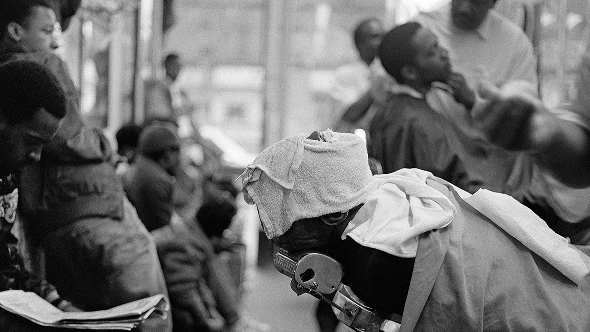 Man's face covered with hot towel, from the photo series House's Barber Shop by Jeffrey Henson Scales