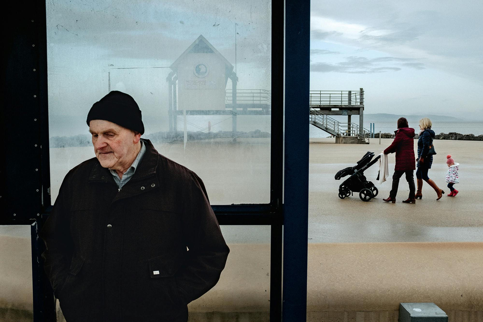 Man at a bus stop by the seaside in in Morecombe, from Merlin Daleman's book Mutiny