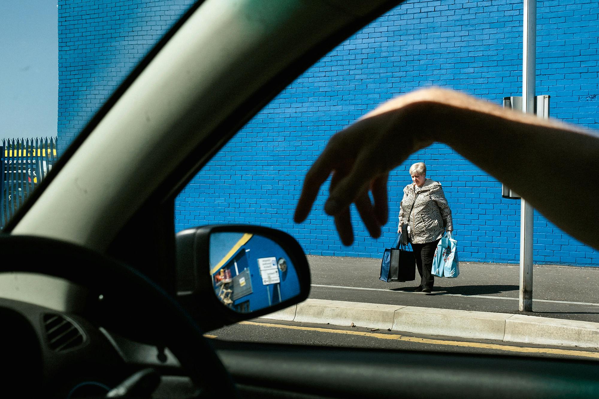 A driver's hand hanging from a car window in Glasgow, from Merlin Daleman's book Mutiny