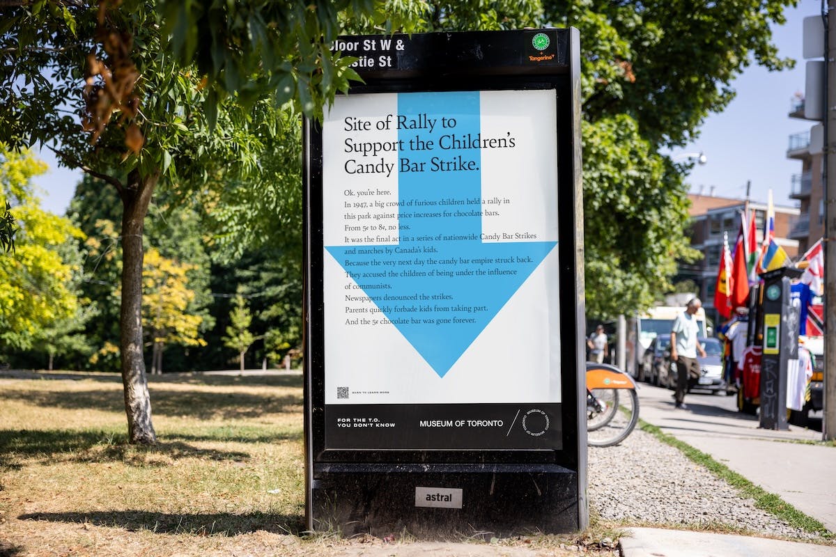 Museum of Toronto outdoor ad that reads 'site of rally to support the children's candy bar strike' with an arrow in the background