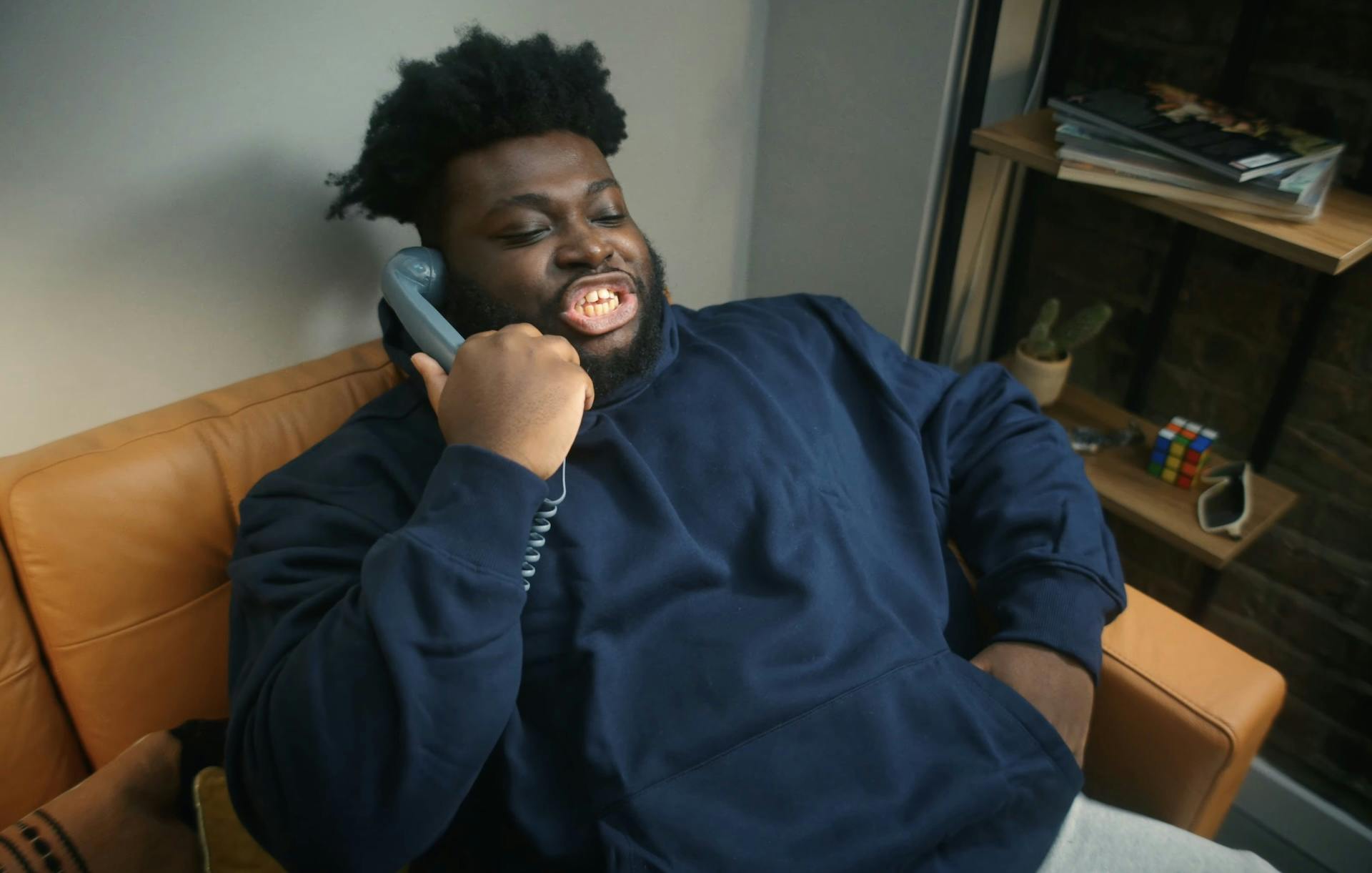 Still from Walkers Jheeeze and Onion ad campaign showing a young person sat on a sofa holding a phone